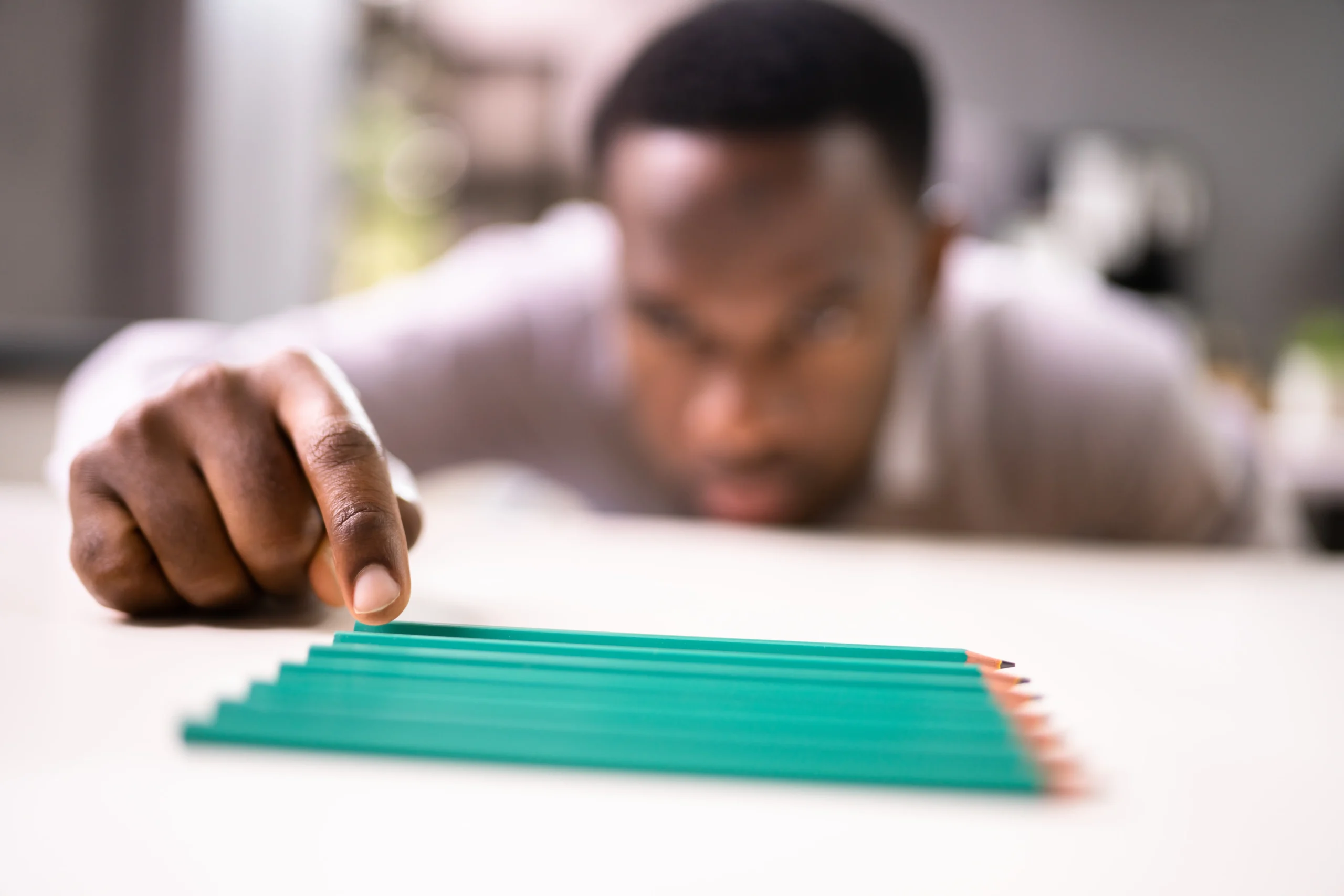 a man pointing at a row of pencils - OCD Treatment Services cover