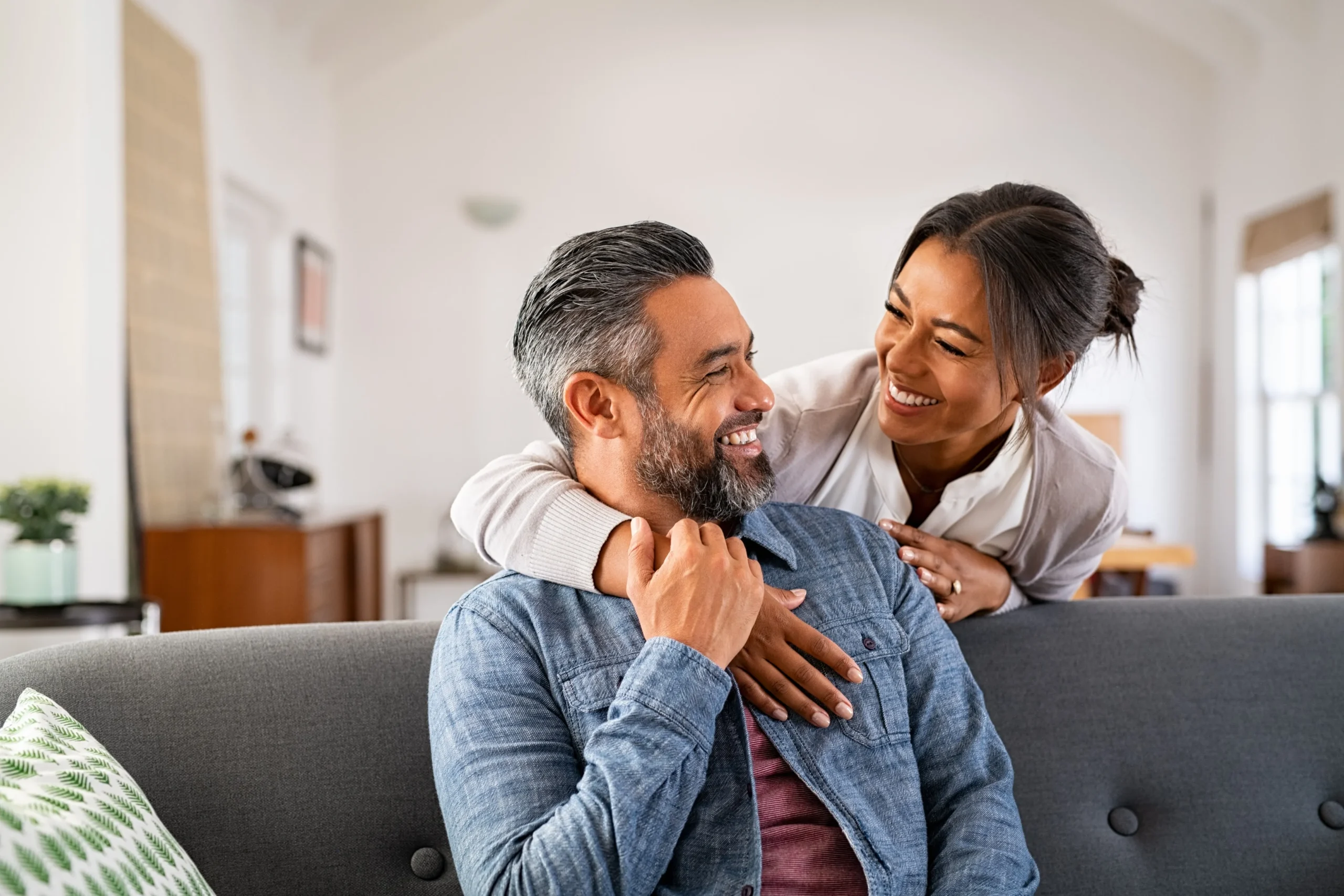 a woman hugging a man on a couch - PTSD Treatment cover