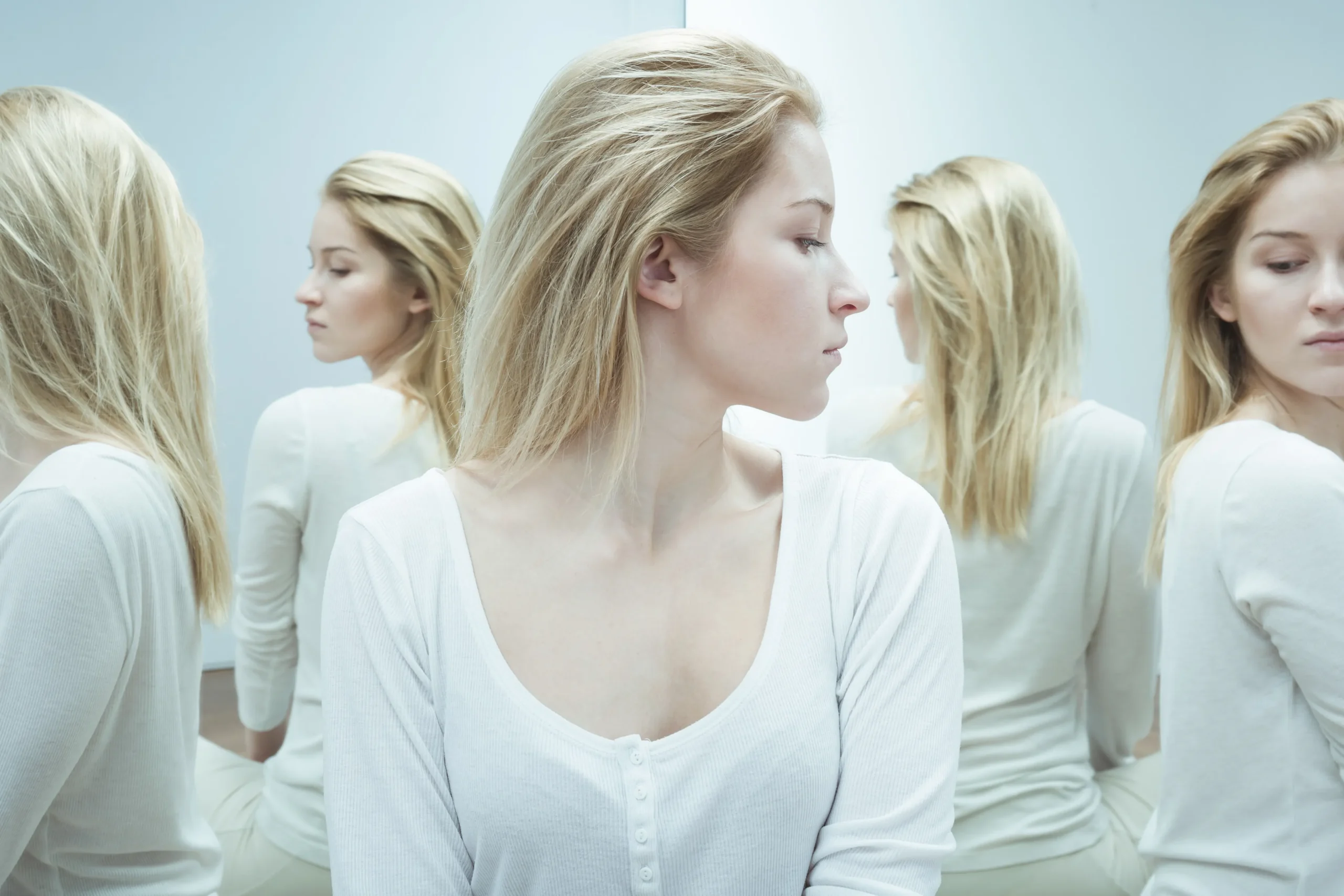 a woman in front of a mirror - Schizophrenia Treatment cover