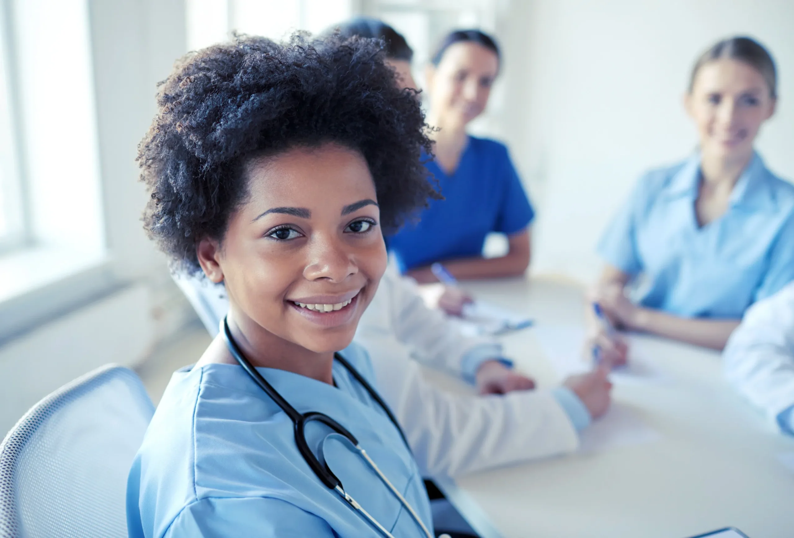 a woman in blue scrubs smiling