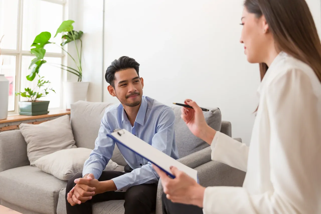 a man sitting on a couch in a therapy room - ADHD