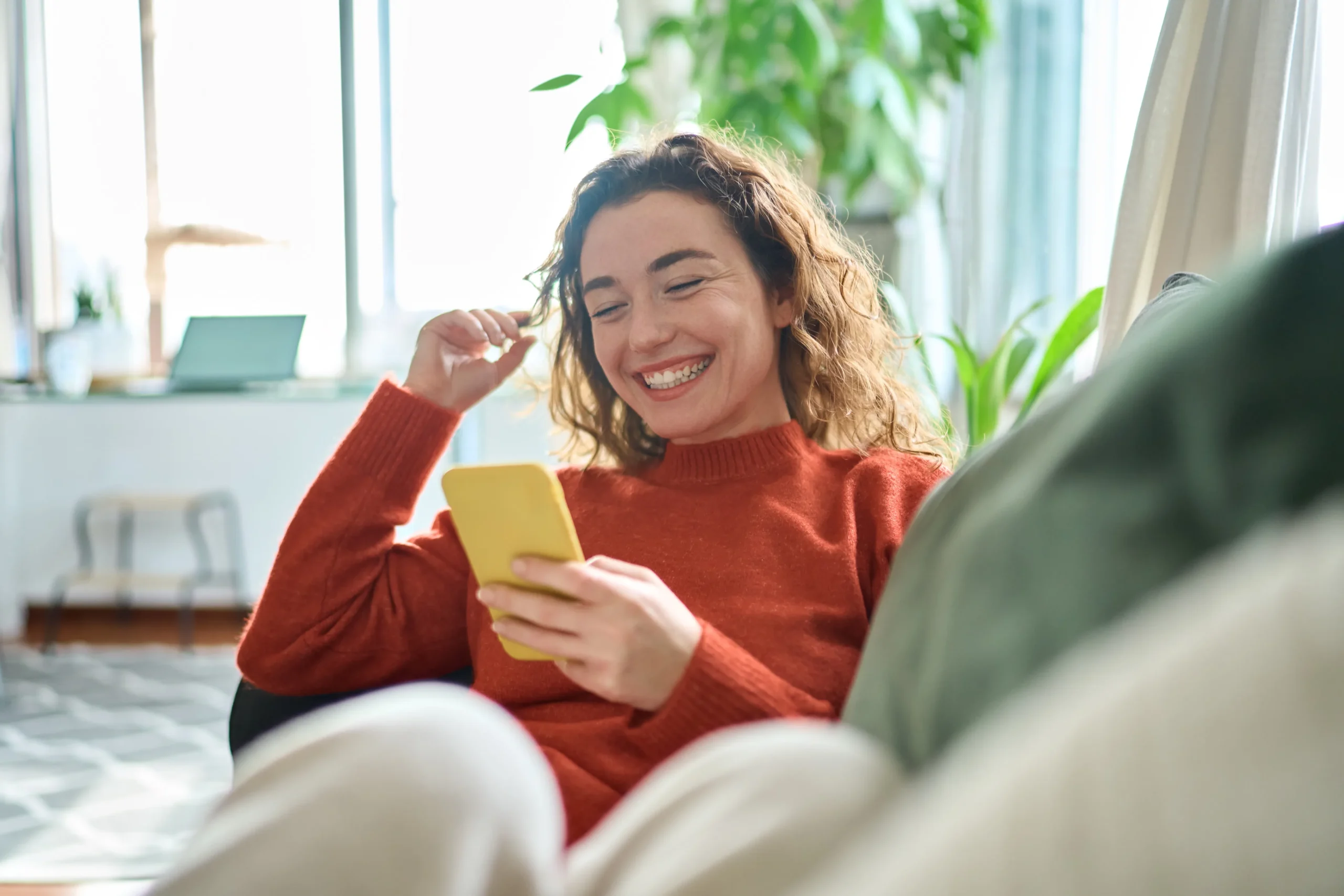 a woman smiling while holding a phone